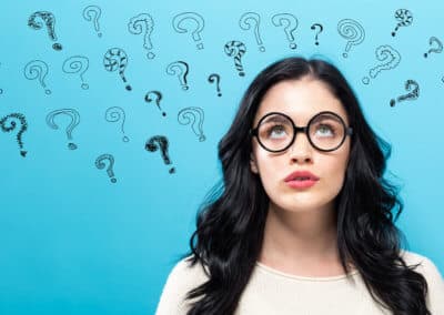 Young woman in a thoughtful pose with question marks